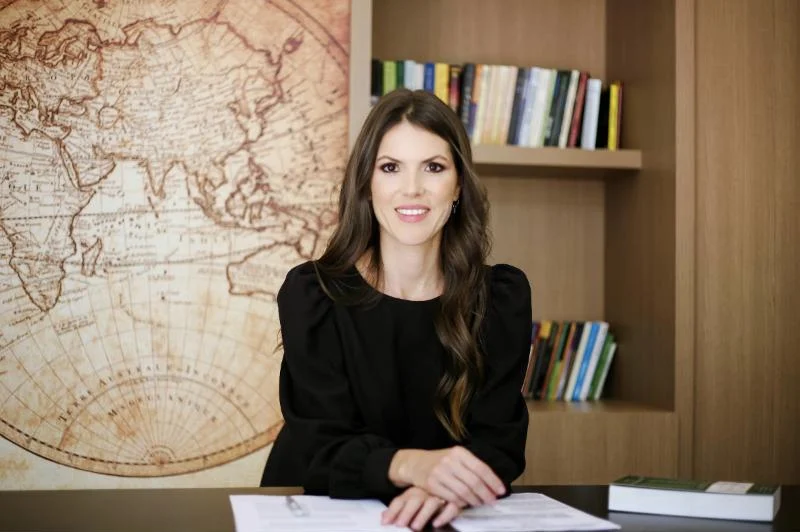 A advogada Camila Renner à mesa de seu escritório